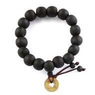 PULSERA CON CUENTAS DE MADERA Y MONEDA DE COBRE.
